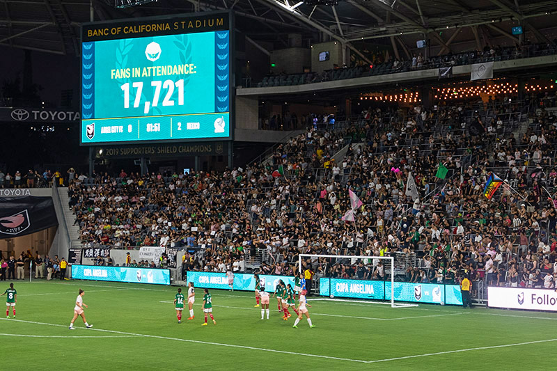 A screen shows the attendance as 17,721 for the Copa Angelina as the teams play in the foreground.